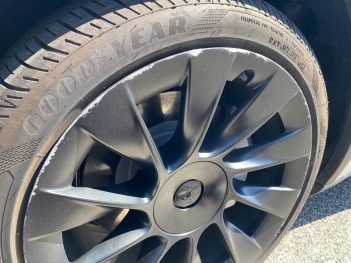 Black Tesla wheel with curb damage